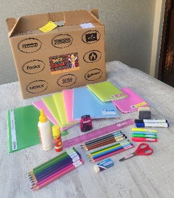 A complete labelled stationery order arranged beside its school box